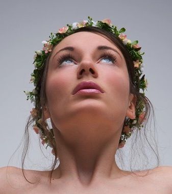 a woman with flowers in her hair looking up