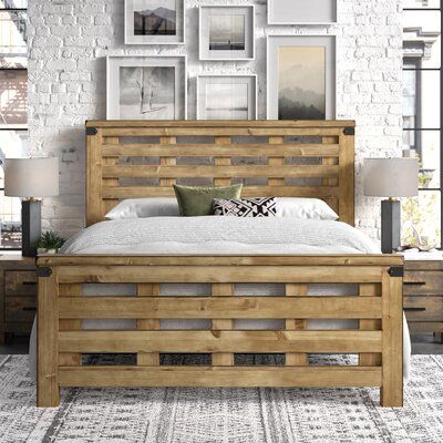 a bed with wooden frame and headboard made out of pallet wood, surrounded by pictures on the wall