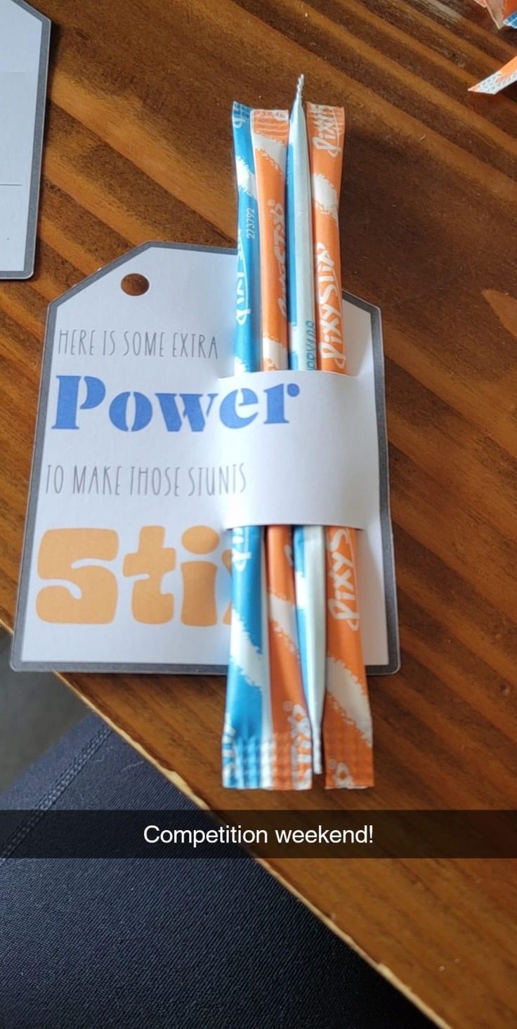 two toothbrushes sitting next to each other on top of a wooden table in front of a card