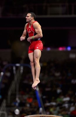 a man in red shorts is jumping on a trampoline at an indoor event