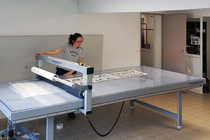 a woman sitting on top of a metal table in a room with tile flooring