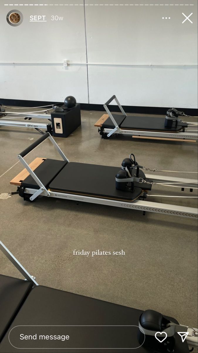 an exercise room with treadmills and machines on the floor in front of a mirror