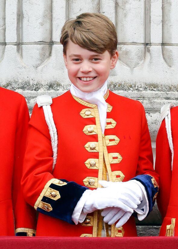 the young boy is dressed in red and smiles for the camera as he stands next to two guards