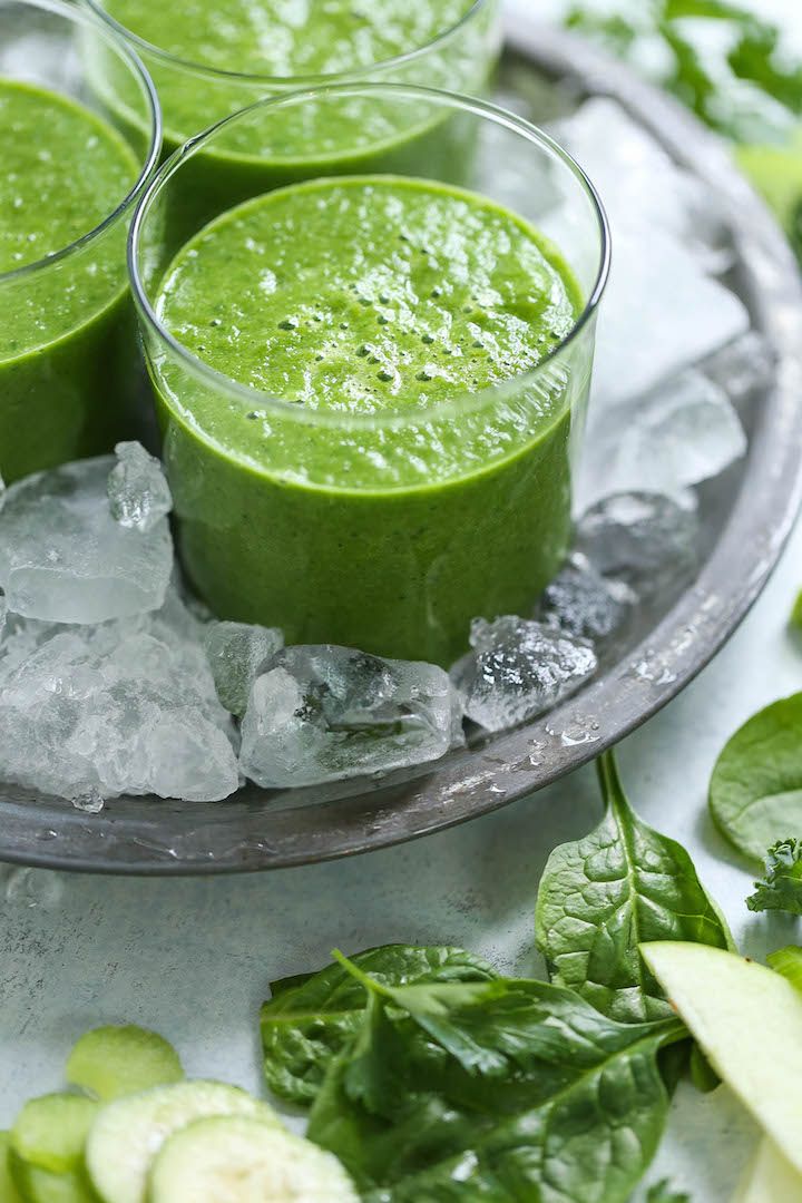 three glasses filled with green smoothie on top of ice