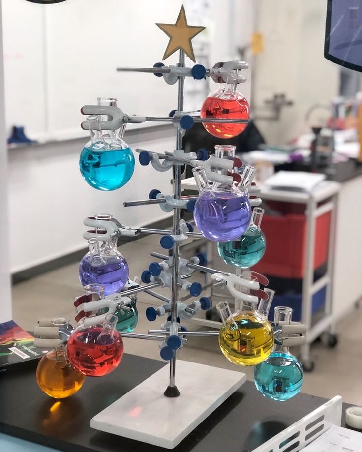 a christmas tree made out of different colored flasks on a table in a lab