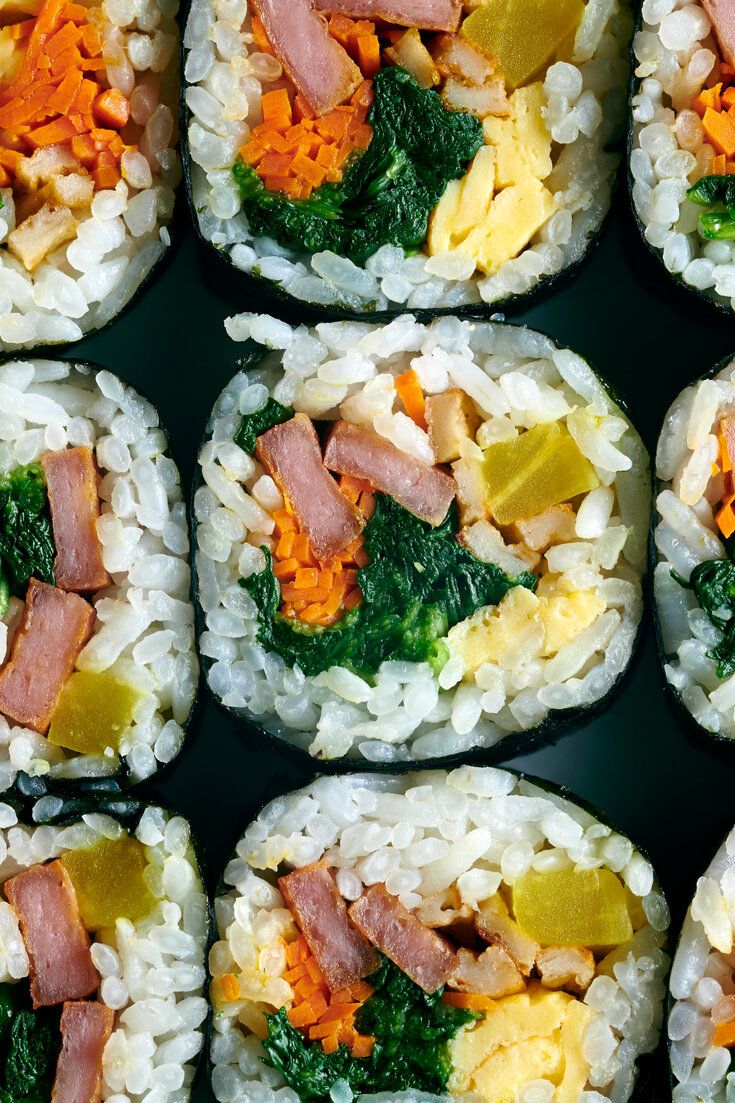 several sushi rolls with vegetables and meat on them