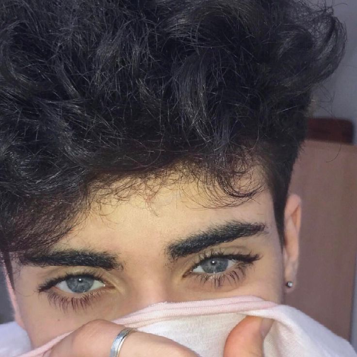 a close up of a person covering his face with a towel and eyeliners