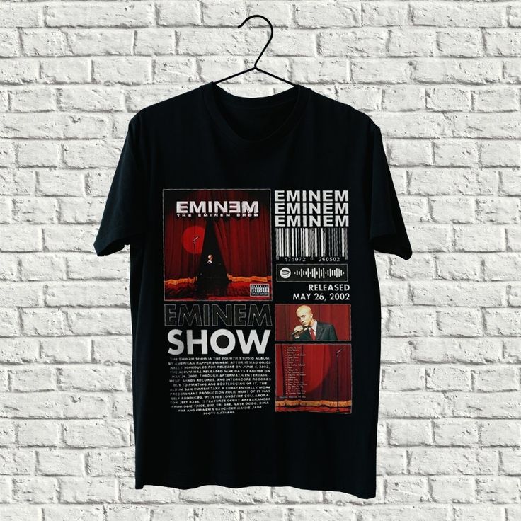 a black t - shirt hanging on a brick wall with the words emim and emim