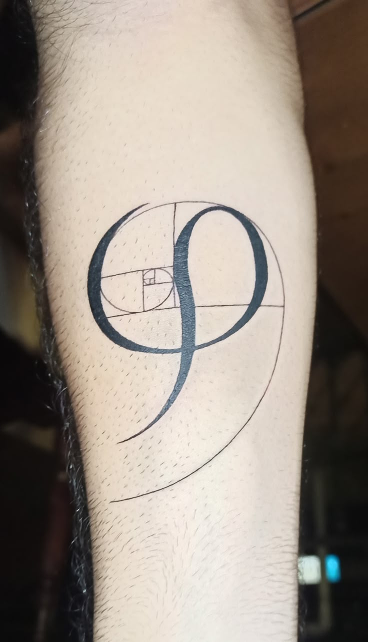 a man with a tattoo on his leg that has the letter q in black ink