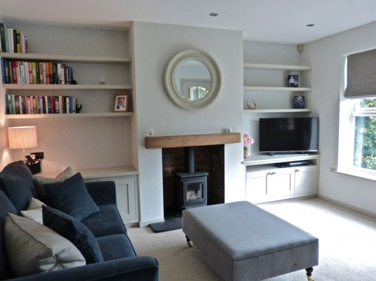 a living room filled with furniture and a flat screen tv mounted on a wall next to a fire place