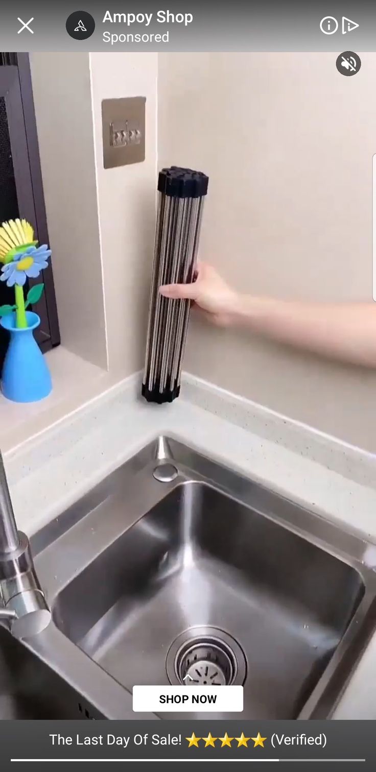 a person is cleaning a kitchen sink with a sponge dispenser on the side