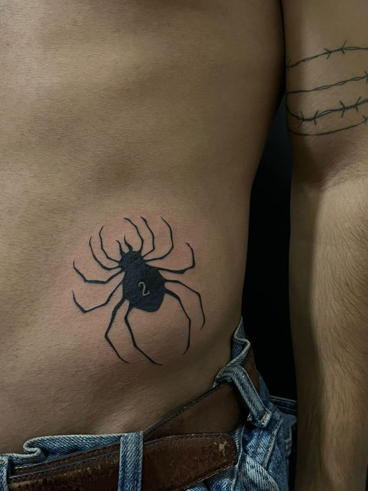 a man with a spider tattoo on his stomach