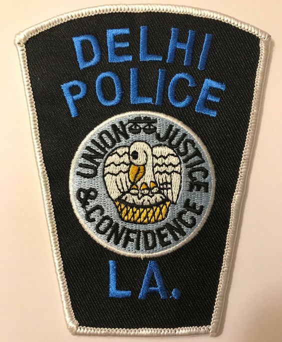 a police patch with the words delhi police and an eagle in blue letters on it