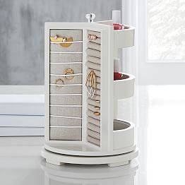 a white jewelry cabinet with drawers on it