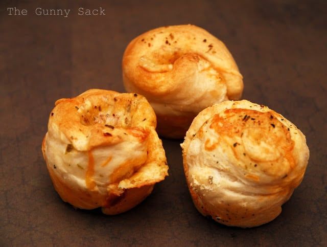 three puffy pastries sitting on top of a brown table next to each other