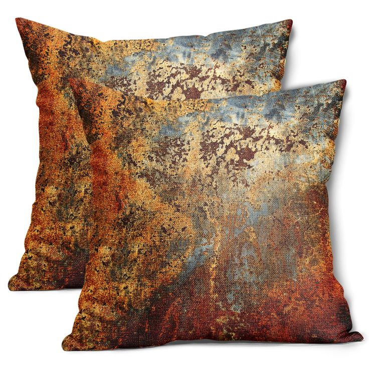 two decorative pillows on white background with rusted paint and gold leafy pattern, one in orange and the other in blue