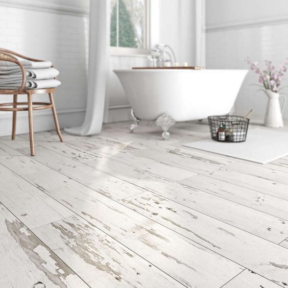 a bathroom with white wood floors and a tub