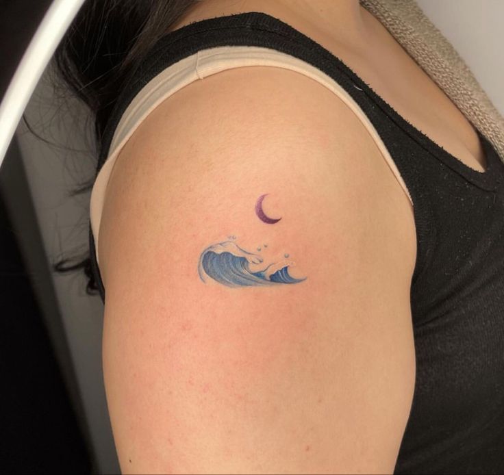 a woman with a tattoo on her arm is looking down at the camera and has a crescent