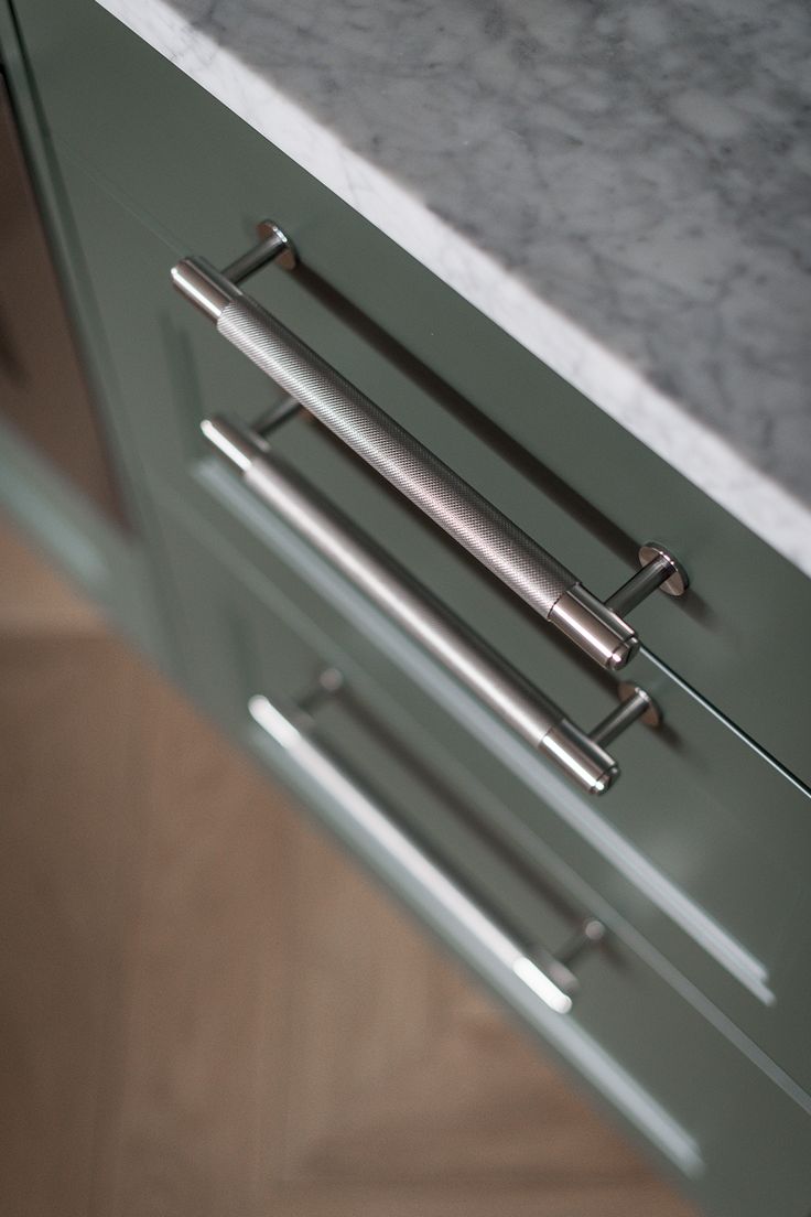 an image of a kitchen drawer with handles on the drawers and marble countertop top