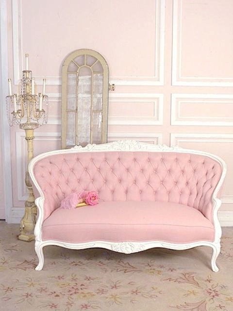 a pink couch sitting on top of a wooden floor