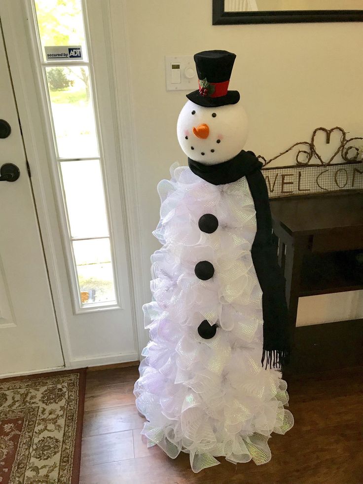 a snowman made out of tulle sitting in front of a door