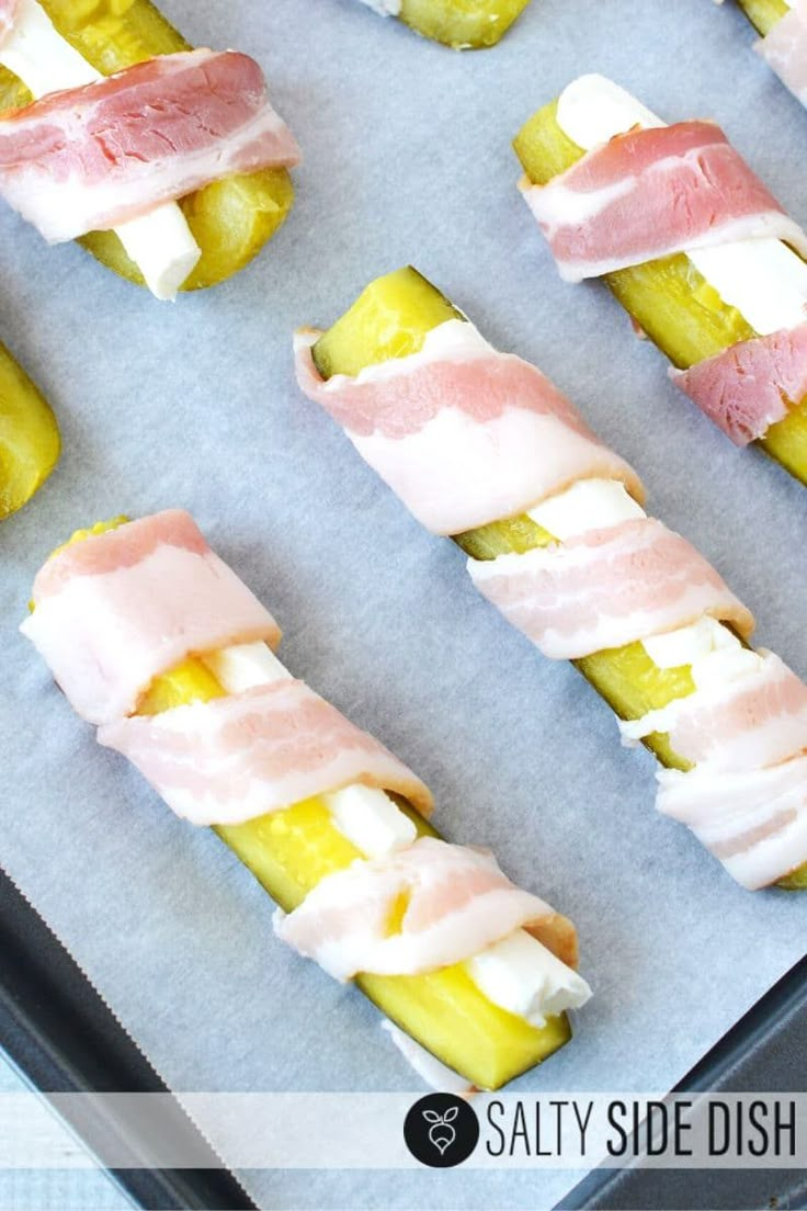 there are many different types of food on the baking sheet, including pickles and bacon