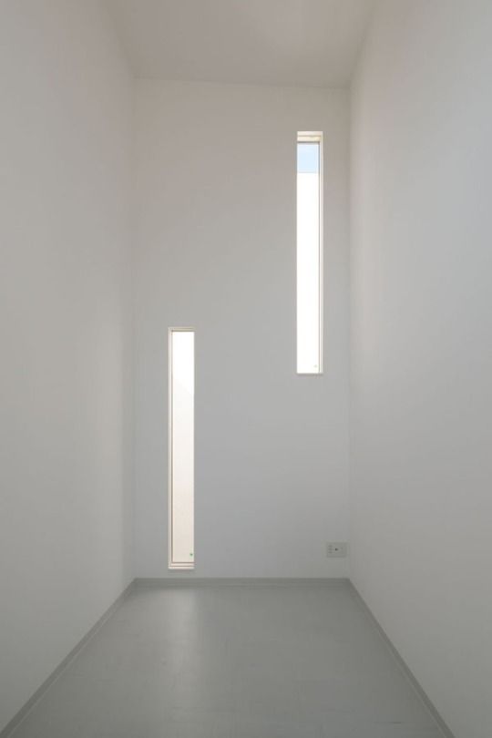 an empty white room with two windows and no one in the room or there is something on the floor