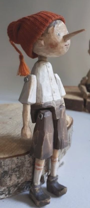 a wooden toy with a red hat on top of it's head and legs