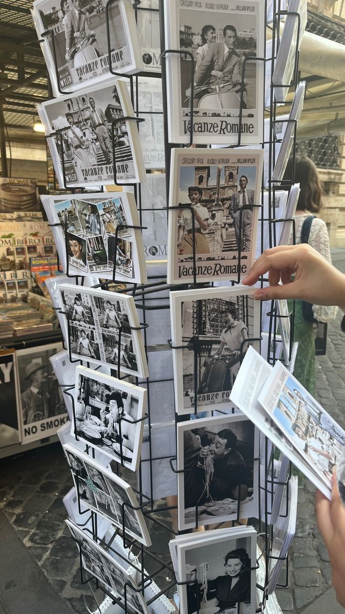 a person is holding up some paper with pictures on it in front of a store