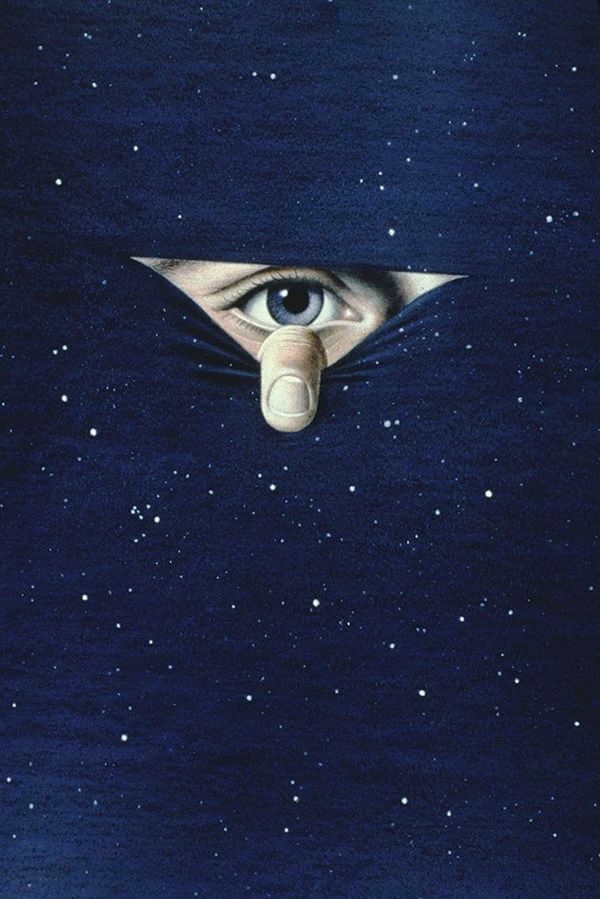 an eye peeks out from behind a blanket with stars in the sky above it