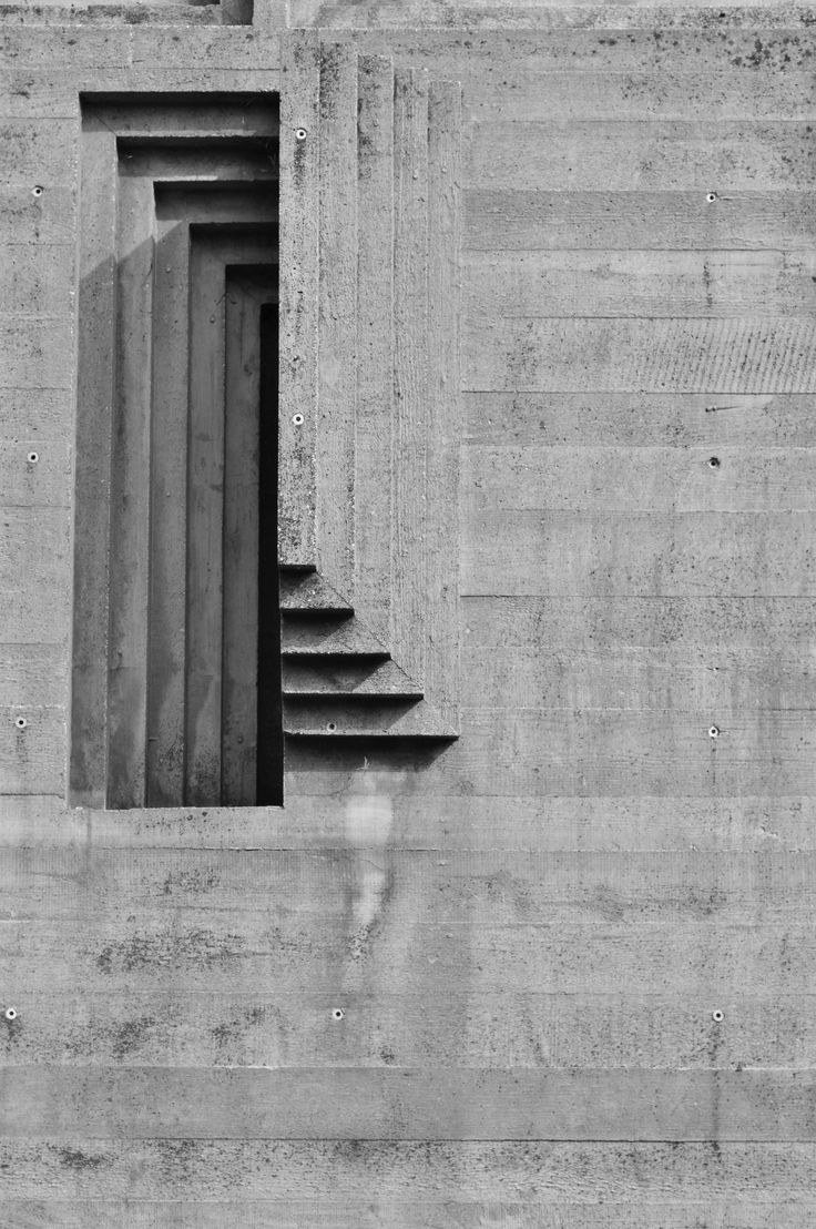 a black and white photo of steps leading up to an open window on the side of a building