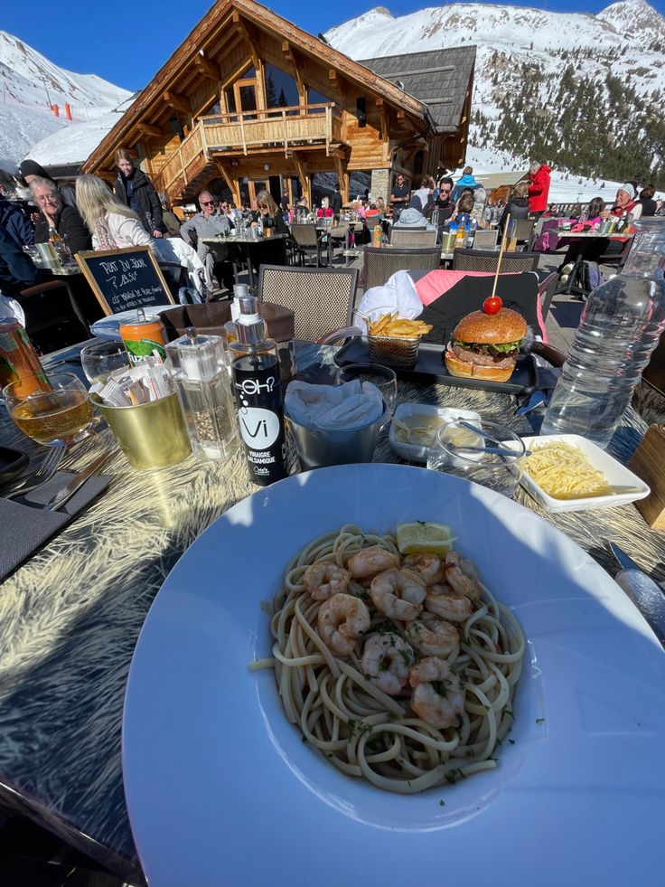 a plate of food on a table with people in the background at a ski resort