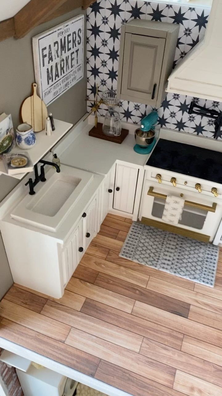 an aerial view of a kitchen with white cabinets and wood flooring on the walls