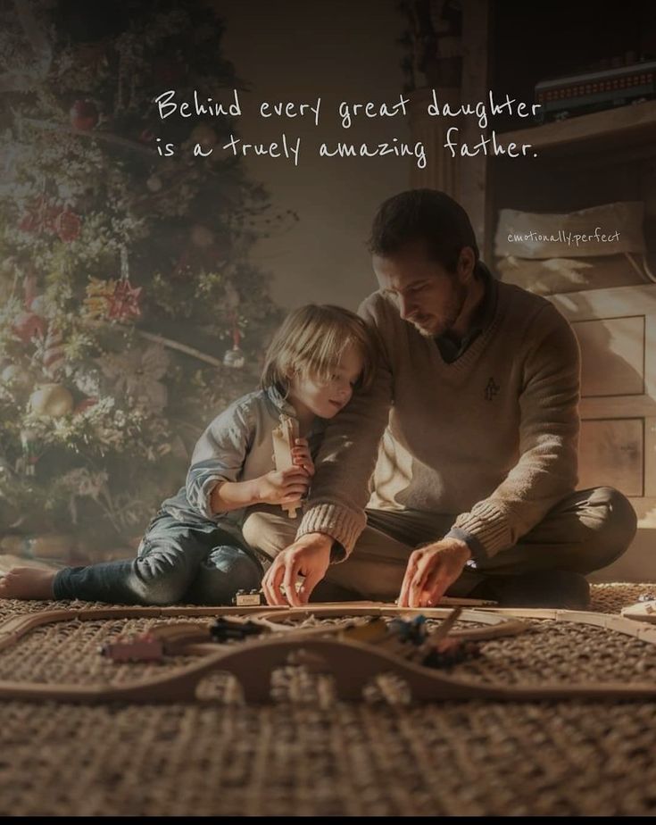 a father and son are sitting on the floor playing with their hands together while looking at something