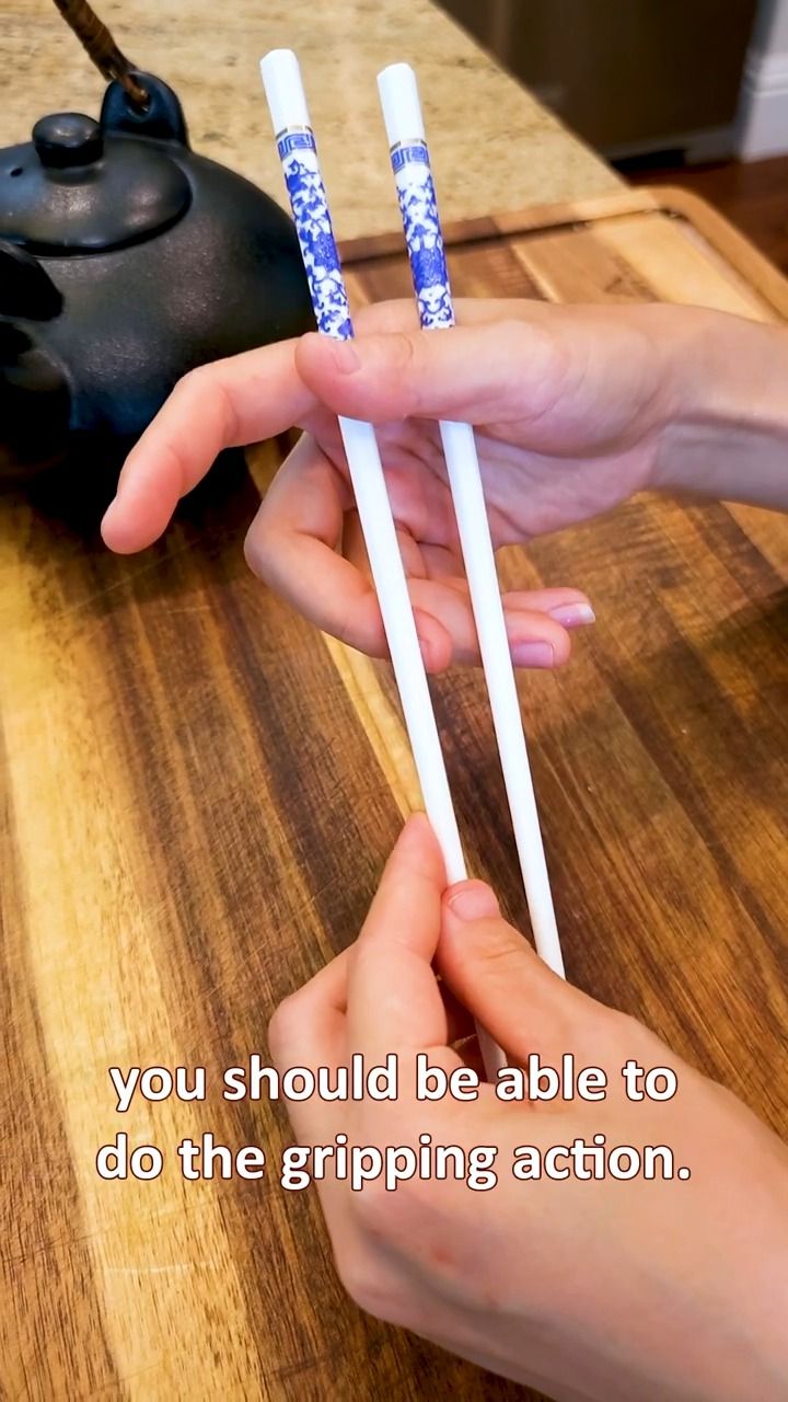 two hands holding chopsticks with the words you should be able to do the gripping action