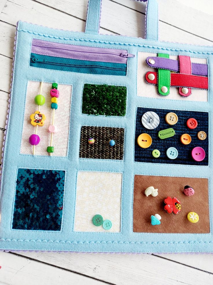 a close up of a bag on a table with buttons and pins attached to it