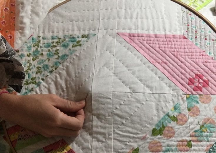 someone is working on a quilt with scissors