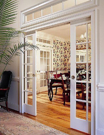 an open door leading to a dining room and living room with wood flooring on the other side