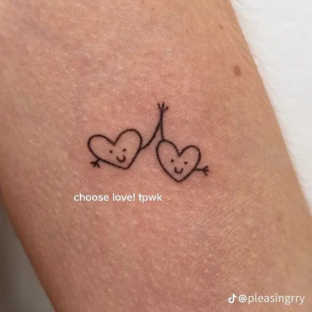 two heart shaped tattoos on the back of a woman's arm