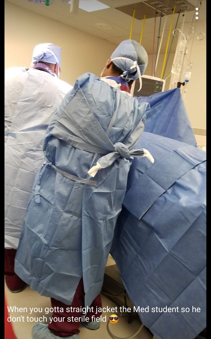 two doctors in scrubs are preparing to perform surgery