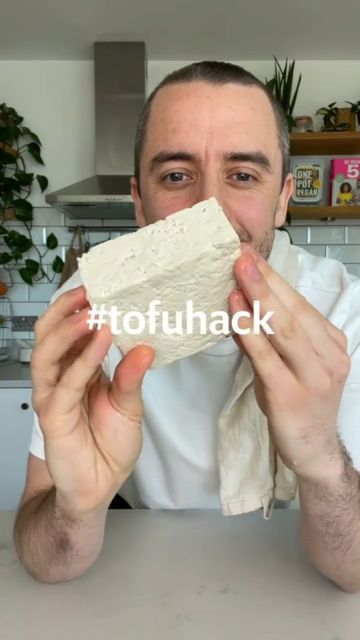 a man sitting at a table with a piece of food in front of his face