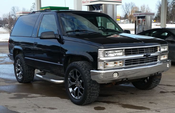 a black suv parked in front of a gas station