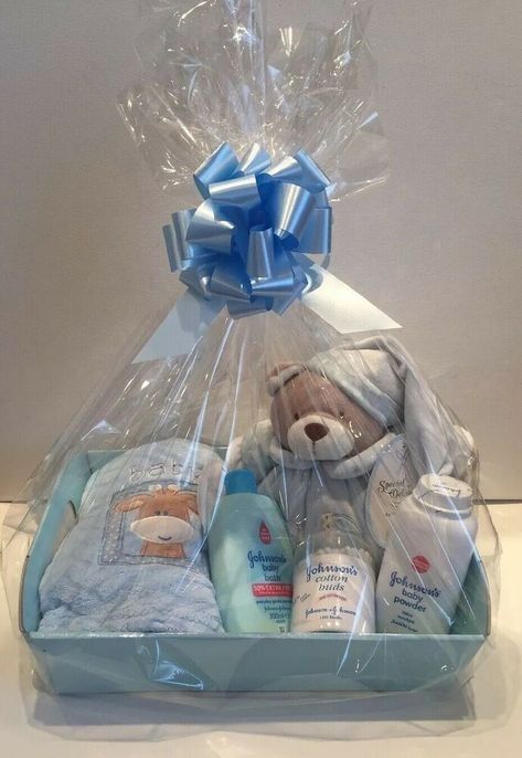 a blue basket filled with baby items on top of a white tablecloth covered counter