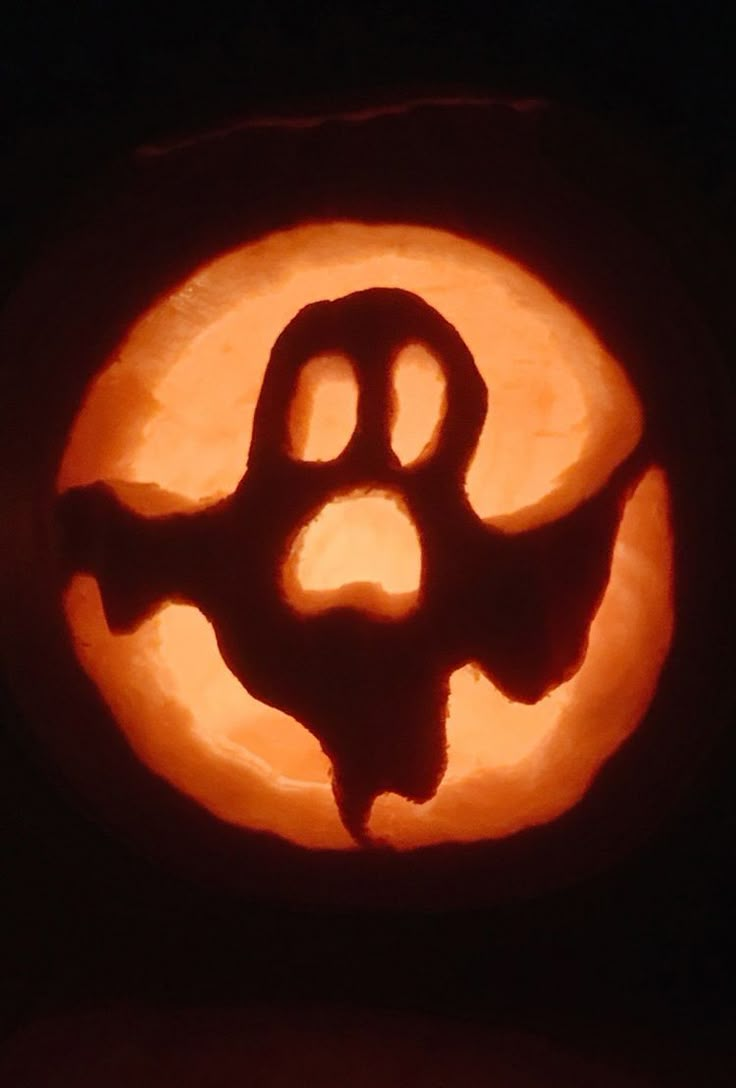 a carved pumpkin with the letter q in it's center and a paw on top