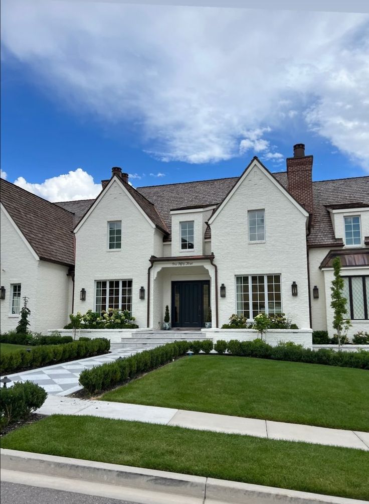 a large white house sitting on top of a lush green field