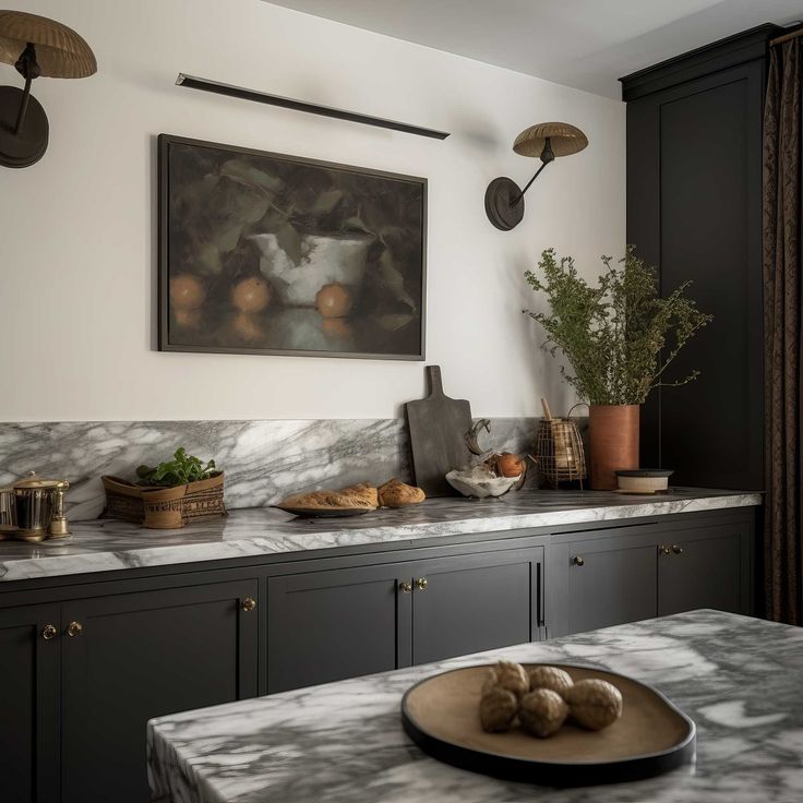 a kitchen with marble counter tops and black cupboards, an art work on the wall