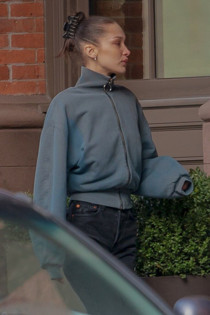 a woman is walking down the street with her hand in her pocket