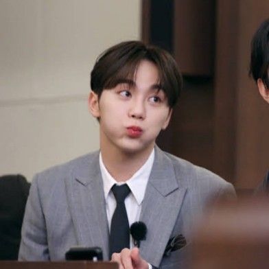 two young men sitting at a table with microphones