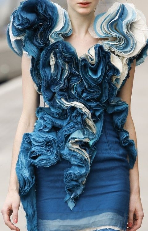 a model walks down the runway in a blue dress with ruffles on it