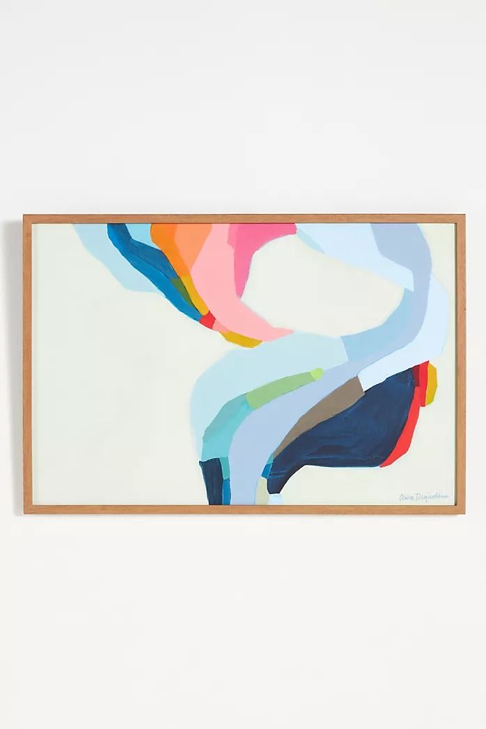 an abstract painting hangs on the wall next to a white wall with a wooden frame